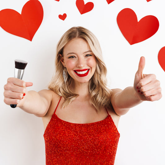 Woman holding a Keshima Flat Top Kabuki Brush with makeup and heart s in the background